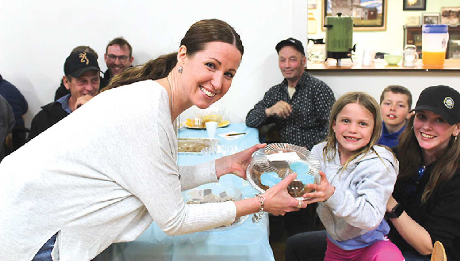 Kari Kosior hands a plate of cupcakes to her daughter Rayna, who was one of the winning bidders at the Fleming Pie Auction on April 5.